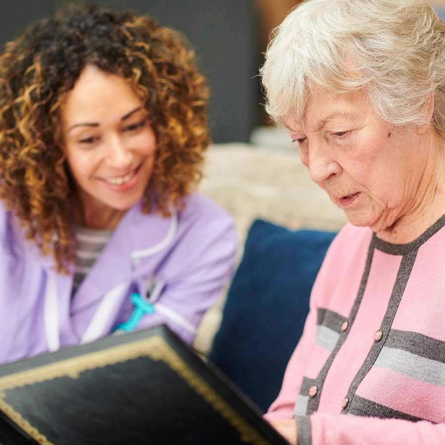 A younger woman and an older woman looking at a photo album together
